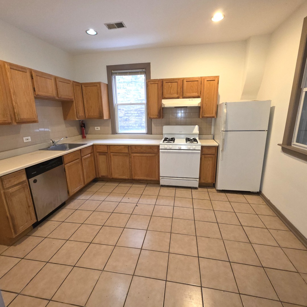 3224 West Armitage Avenue, Unit 2 Chicago, IL 60647 - Photo 5 of 12 a kitchen with a sink a stove a refrigerator and cabinets