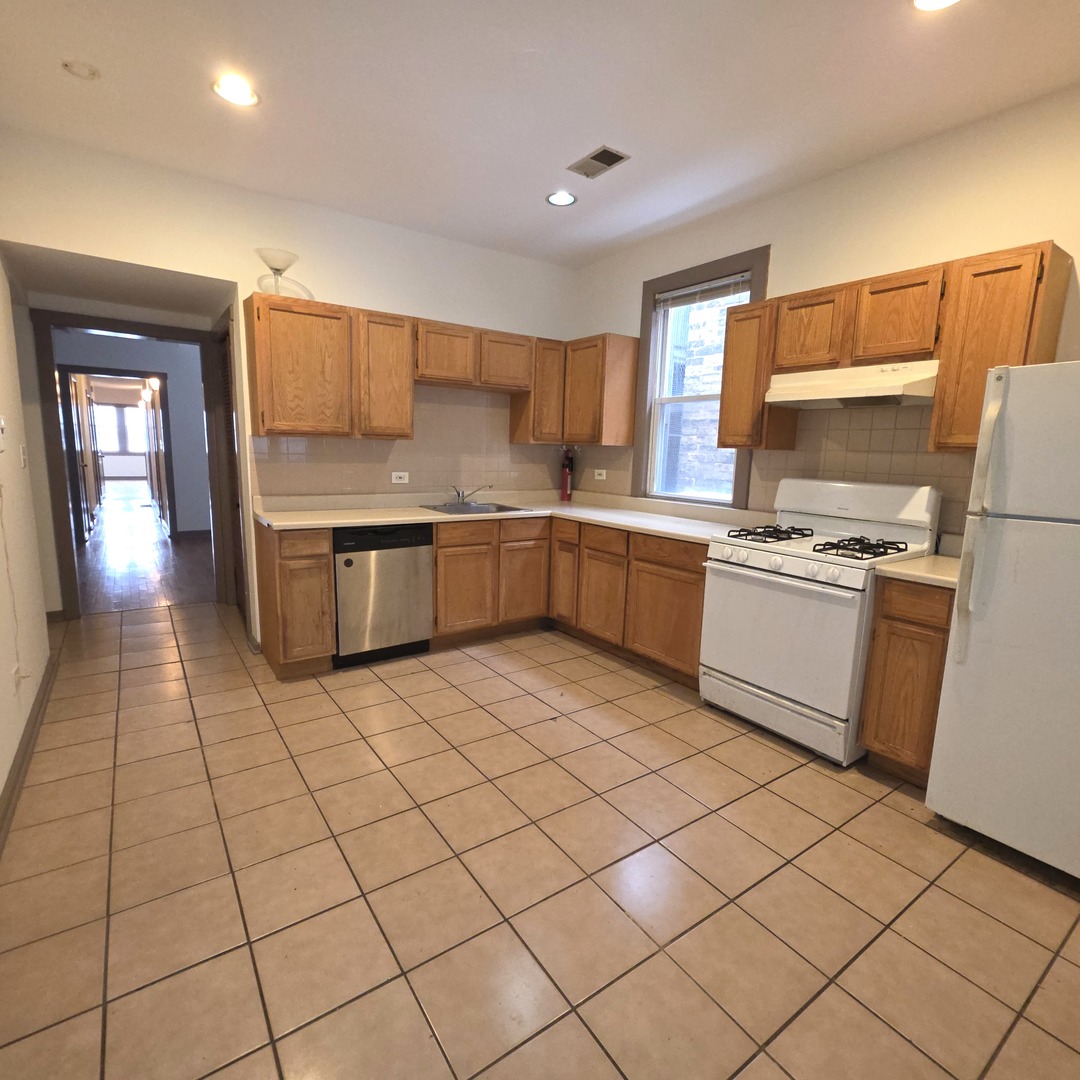 3224 West Armitage Avenue, Unit 2 Chicago, IL 60647 - Photo 6 of 12 a kitchen with stainless steel appliances a sink counter space and cabinets