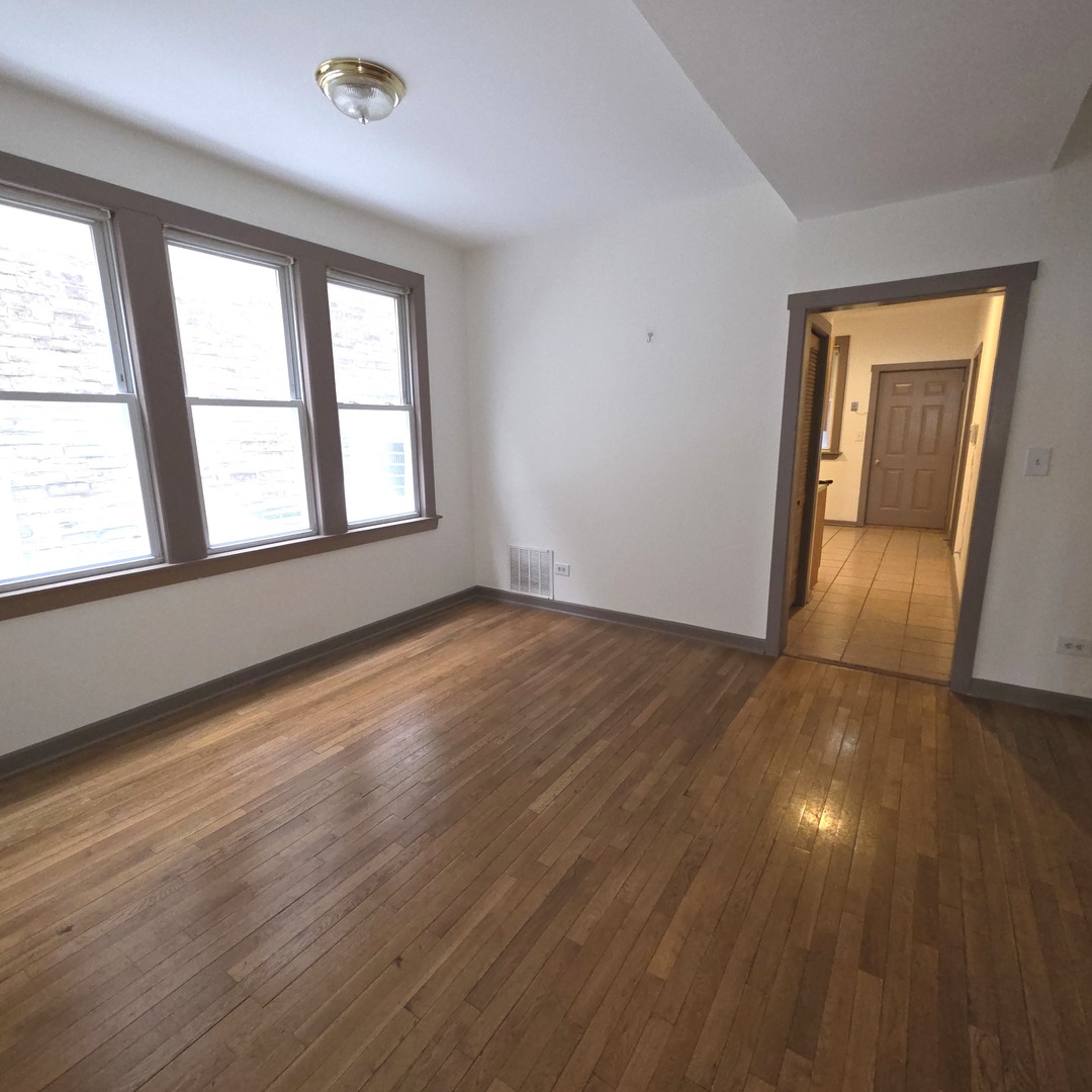 3224 West Armitage Avenue, Unit 2 Chicago, IL 60647 - Photo 7 of 12 an empty room with wooden floor and windows