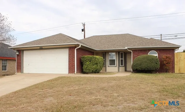 a front view of a house with a garden and garage