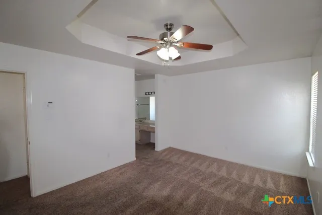 a view of an empty room with a chandelier fan