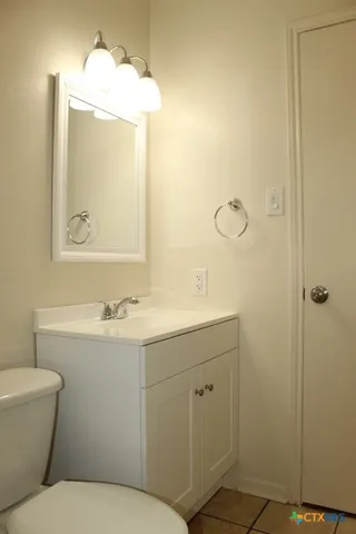 a bathroom with a toilet sink and mirror