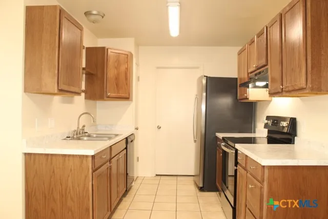 a kitchen with a sink a refrigerator and a cabinets