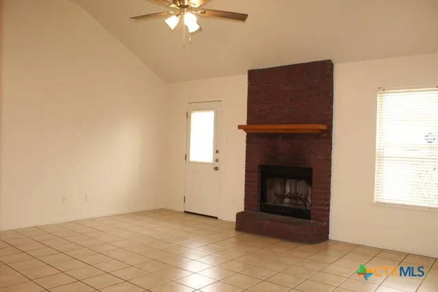 an empty room with windows and fireplace