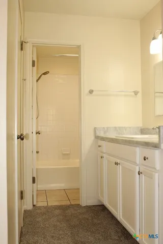 a bathroom with a granite countertop sink mirror and shower