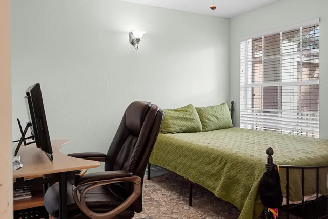 a bedroom with a bed a desk and chair