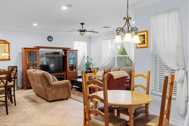 a living room with furniture a ceiling fan and a flat screen tv
