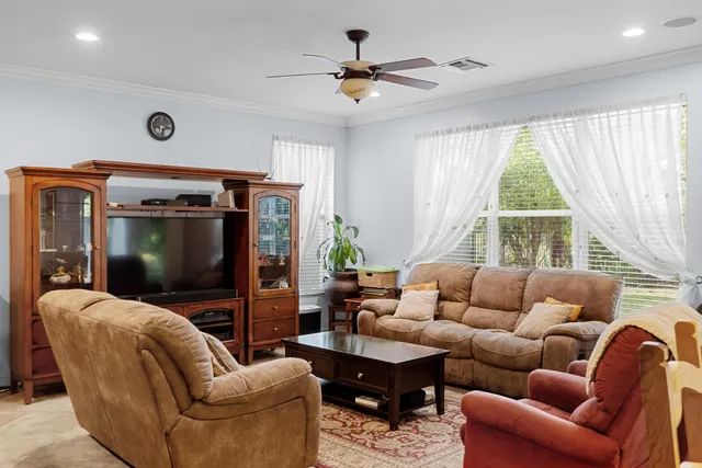 a living room with furniture ceiling fan and a window