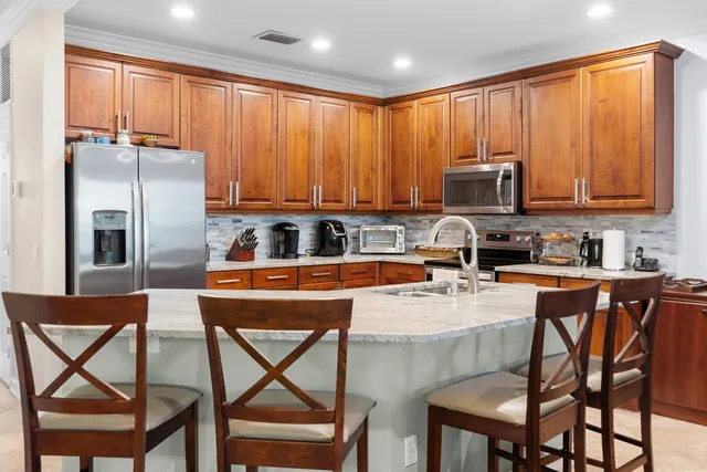 a kitchen with stainless steel appliances granite countertop a table chairs microwave and sink
