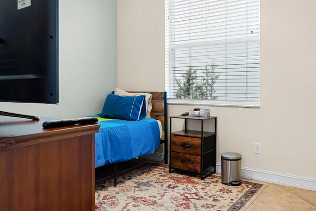 a bedroom with a bed and wooden floor