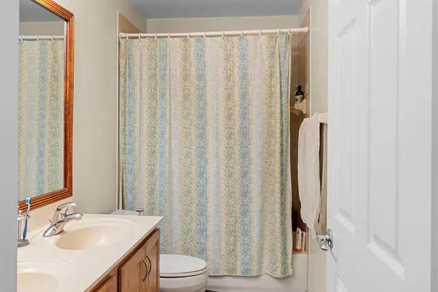 a bathroom with a sink a toilet and shower curtain