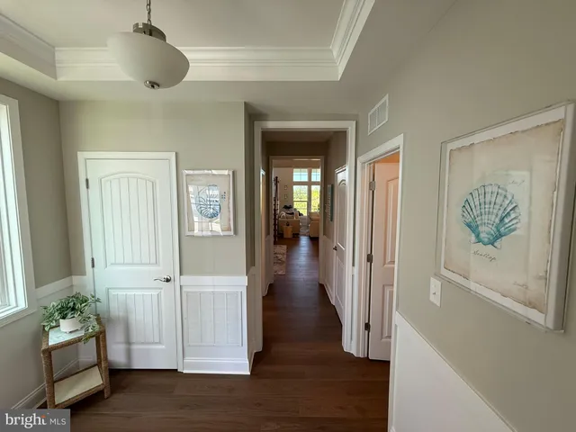 a hallway with wooden floor and a chandelier