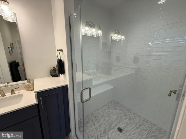 a bathroom with a shower sink vanity and mirror