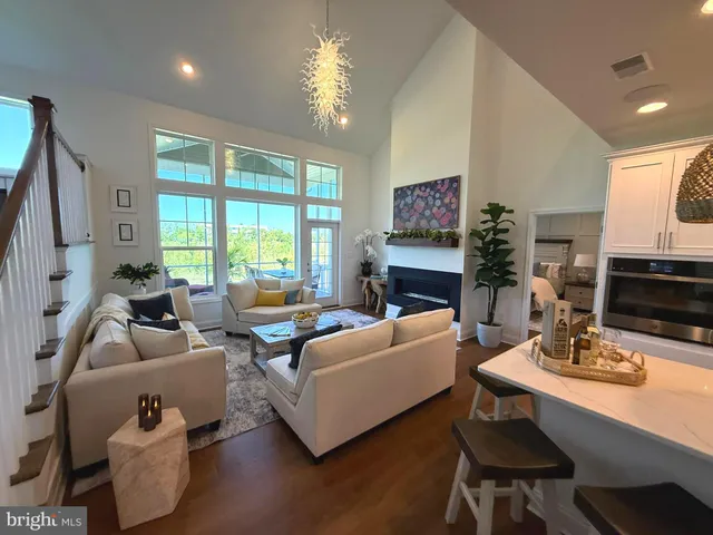 a living room with furniture a fireplace a lamp and a large window