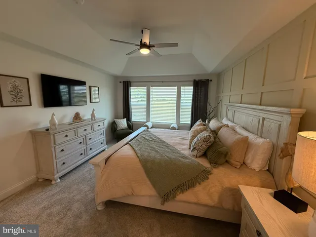 a bedroom with a bed and a flat tv screen on dresser