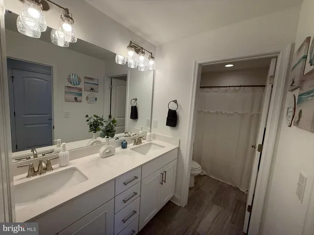 a spacious bathroom with double vanity a and a mirror