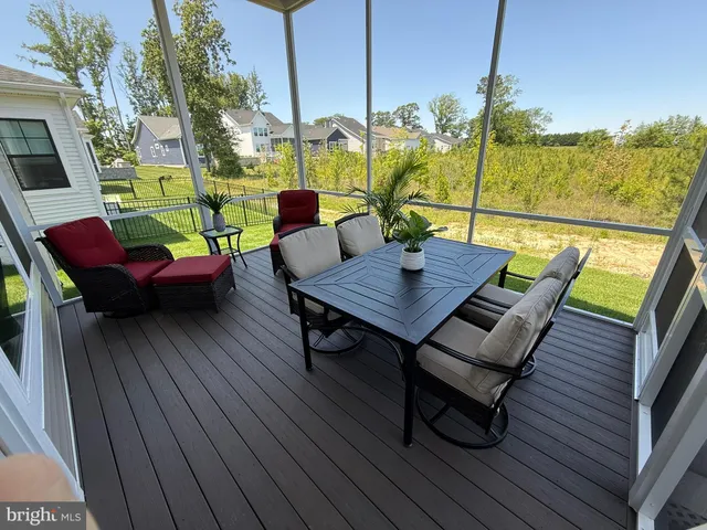 a view of table and chairs on wooden deck