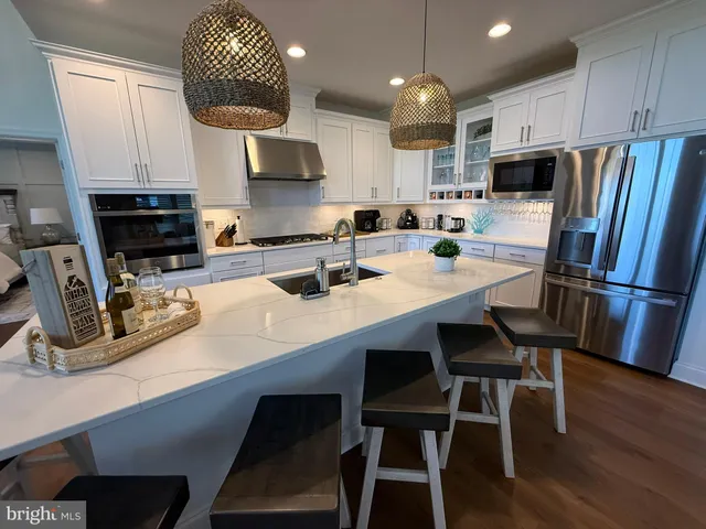 a kitchen with kitchen island granite countertop a table chairs microwave and cabinets