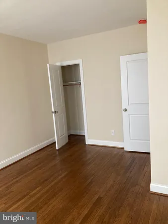 an empty room with wooden floor and closet
