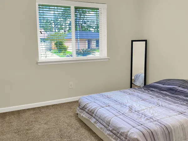 a bedroom with a bed and a window