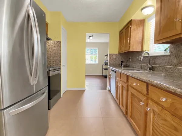 a kitchen with stainless steel appliances granite countertop a refrigerator and a sink