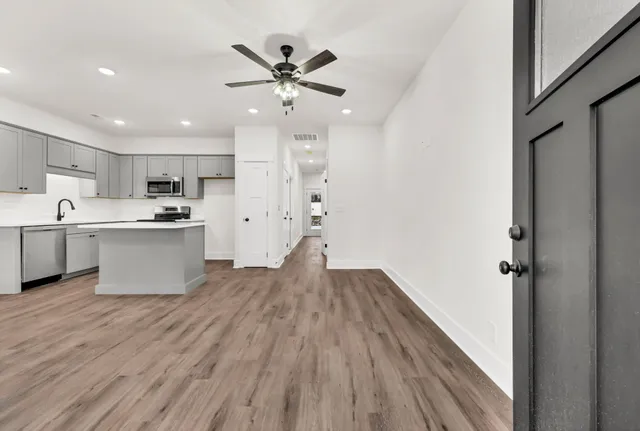 a kitchen with a refrigerator and white cabinets