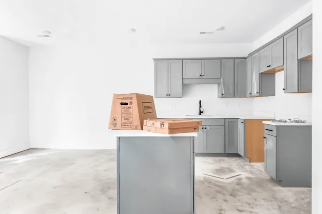 a kitchen with a sink refrigerator and cabinets