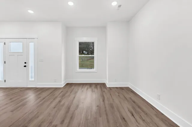 wooden floor in an empty room with a window