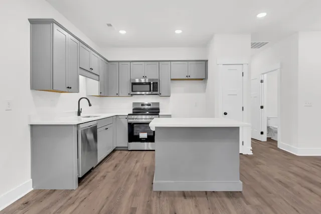 a kitchen with white cabinets and stainless steel appliances