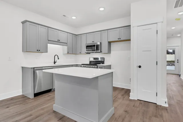a kitchen with a sink a stove top oven and white kitchen