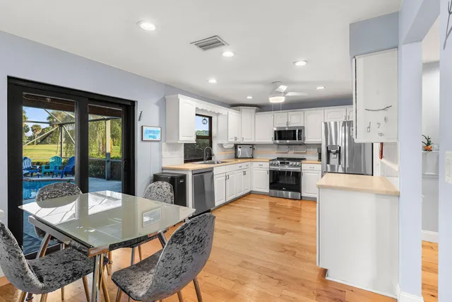 a kitchen with a table chairs refrigerator and cabinets