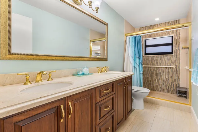 a bathroom with a granite countertop sink mirror vanity and toilet