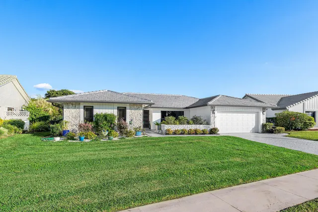 a front view of a house with a garden and trees