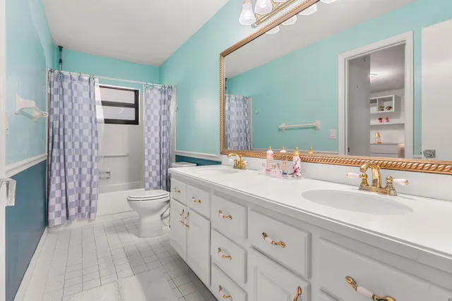 a bathroom with a double vanity sink toilet and shower