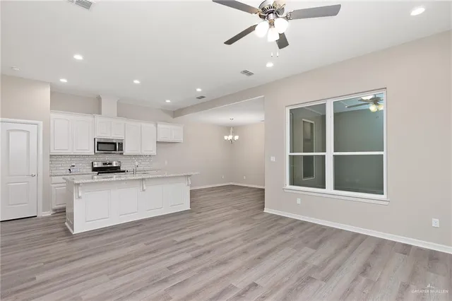 a view of kitchen with granite countertop cabinets and wooden floor