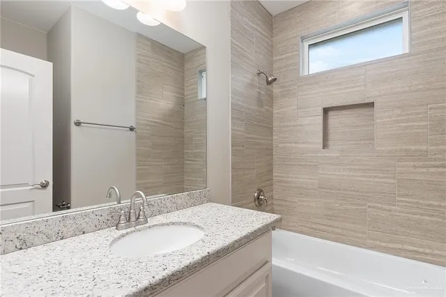 a bathroom with a granite countertop sink toilet and bathtub