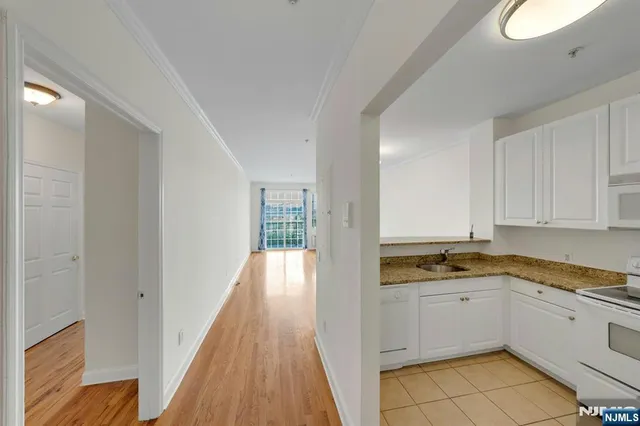 a view of a kitchen with wooden floor and electronic appliances