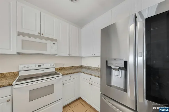 a kitchen with white cabinets and white appliances