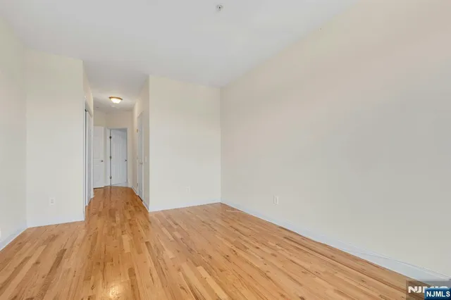 a view of a bedroom with wooden floor and natural light
