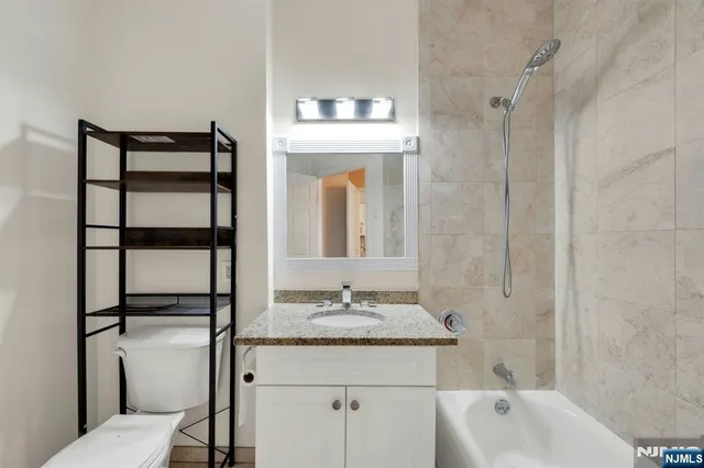 a bathroom with a granite countertop sink and a mirror