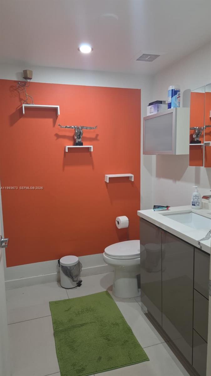 690 Southwest 1st Court, Unit 1722 Miami, FL 33130 - Photo 21 of 35 a bathroom with a sink a toilet and mirror