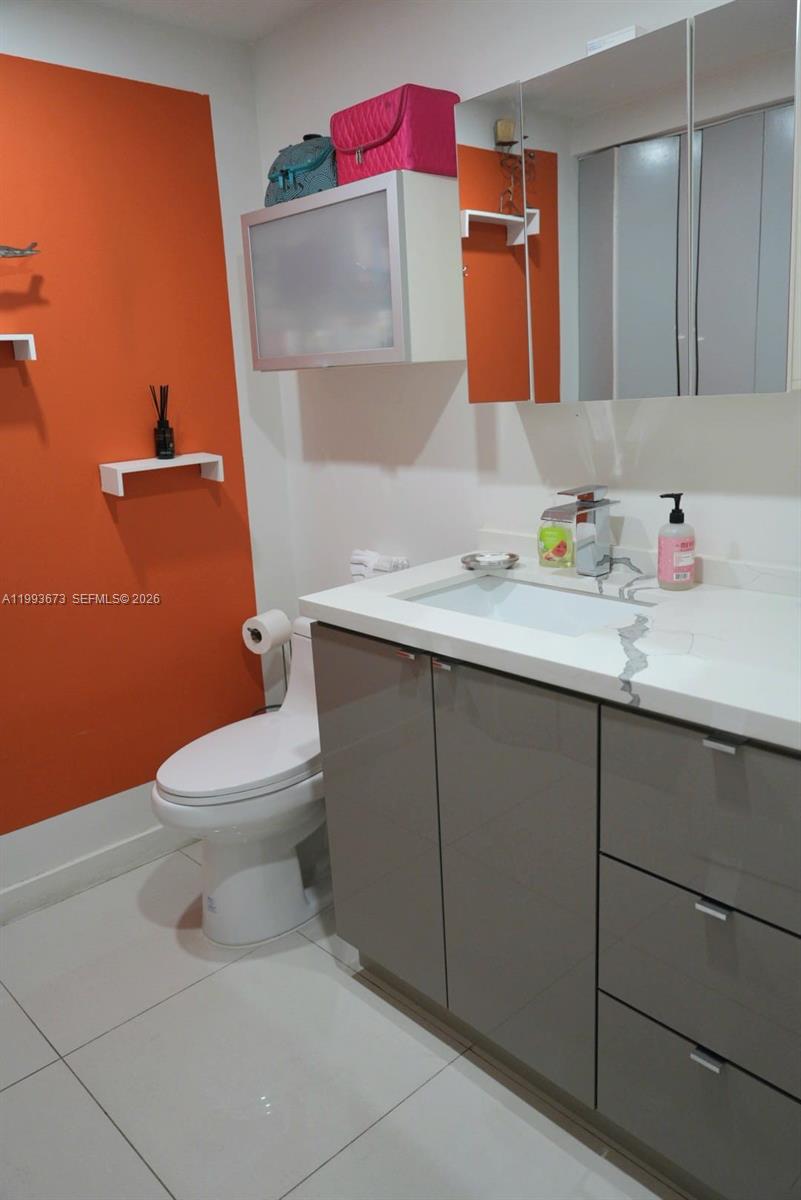 690 Southwest 1st Court, Unit 1722 Miami, FL 33130 - Photo 22 of 35 a bathroom with a toilet sink vanity and mirror