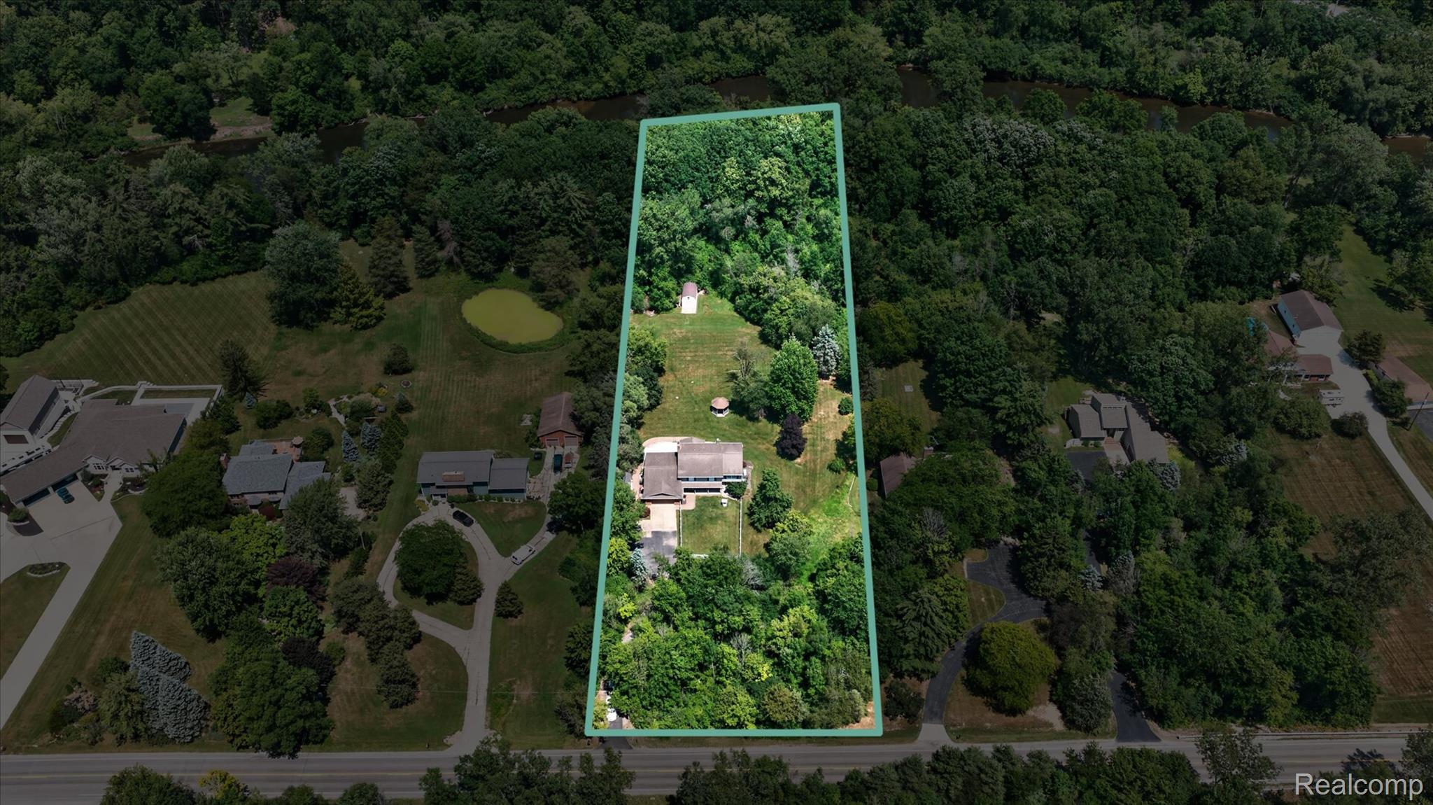 7186 East River Road Flushing, MI 48433 - Photo 31 of 47 Expansive property outlined by a green border, featuring a large residence with a multi-gabled roof and an extended driveway
