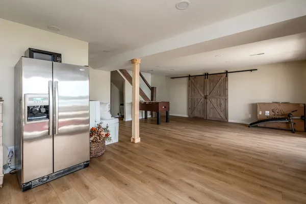 a view of a refrigerator in kitchen and an empty room