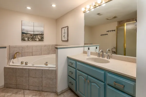 a bathroom with a tub sink and mirror