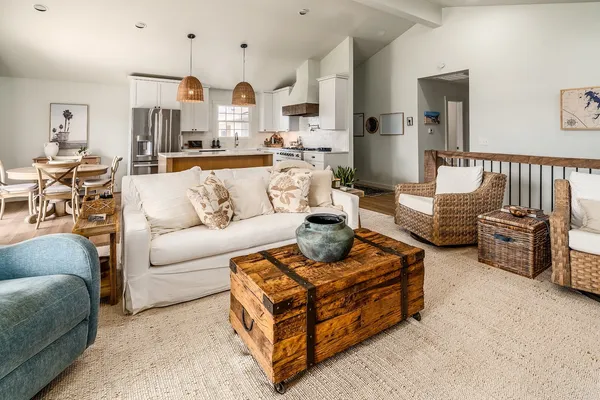 a living room with furniture kitchen view and a large window