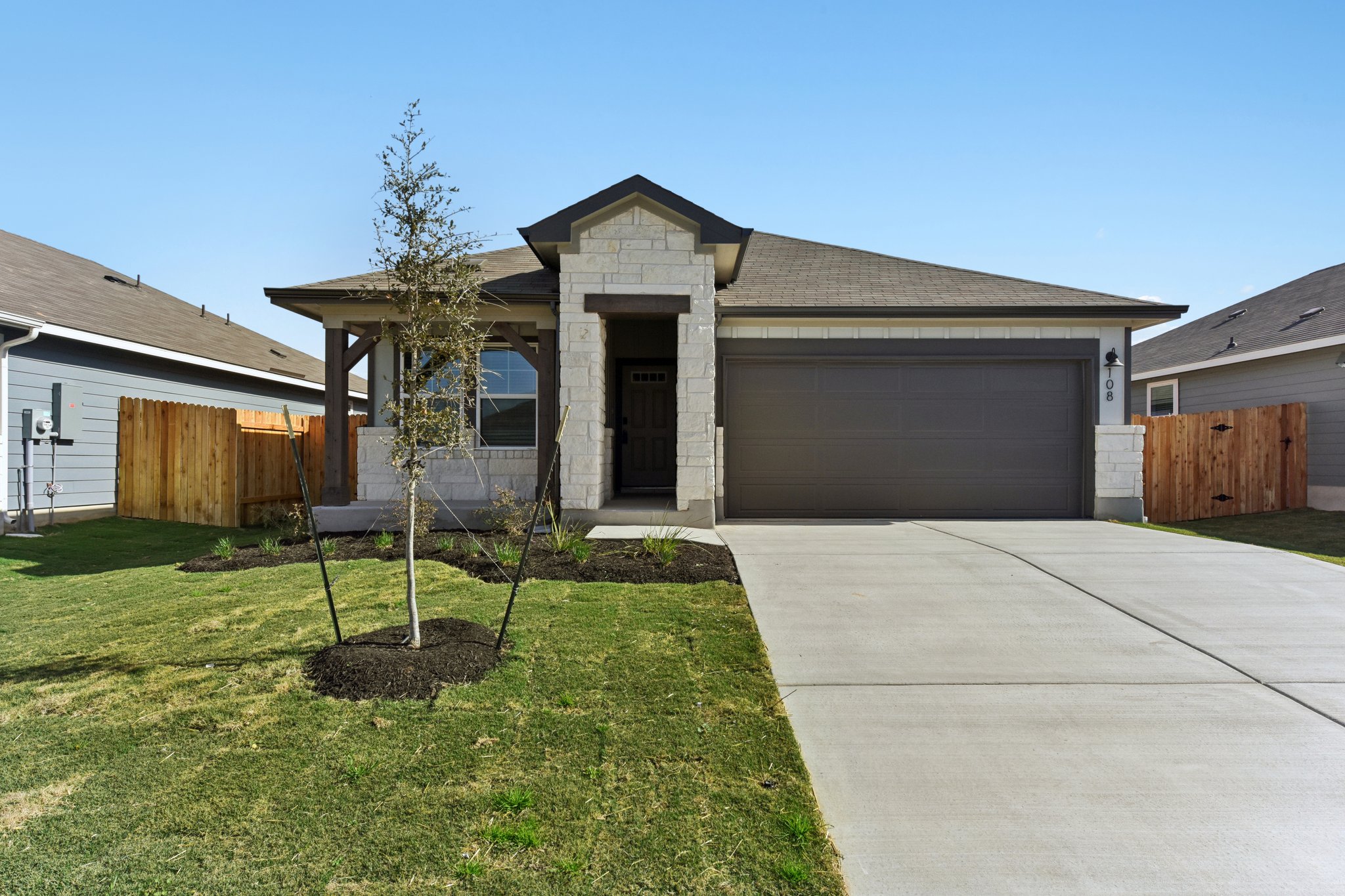 108 Honey Bee Road Jarrell, TX 76537 - Photo 1 of 1 Ranch-style house featuring stone siding, driveway, and an attached garage