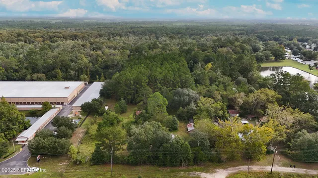 an aerial view of residential houses with outdoor space and trees