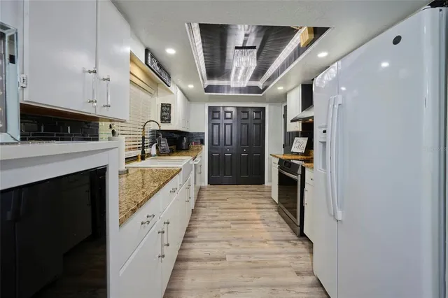 a kitchen with granite countertop a sink and cabinets