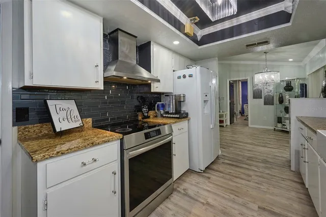 a large kitchen with stainless steel appliances granite countertop a large counter top a stove and a sink